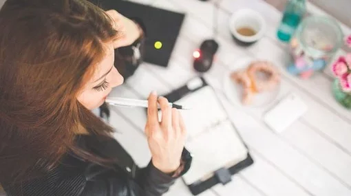 Een vrouw die een motivatiebrief schrijft